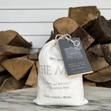 A bag of The Mill's Whole Grain Pancake Mix shown on a marble table top with stacked wood in the background. 