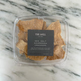 A box of The Mill's Sea Salt Sourdough Crackers shown on a marble table top. 